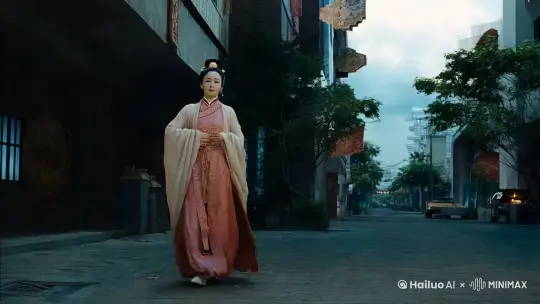 画面以降格拍摄呈现，展现中国古装美女变身白色巨蟒的动作，增加紧迫感。画面在一个白天城市展开，焦点是一位披着飘逸斗篷的女子。环境光线昏暗，中国古装美女从远处走向镜头，一边走一边紧紧裹住身上的斗篷，斗篷随着她的步伐轻轻飘动。当斗篷完全包裹住女子时，斗篷突然掉落在地，一只白色巨蟒从斗篷内迅速飞出，留下空空如也的斗篷。 by Hailuo AI Video Generator