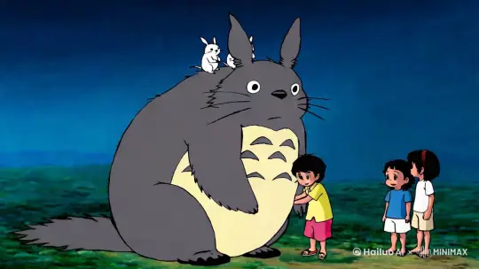 这张图片来自宫崎骏的动画电影《龙猫》。图片中巨大的灰色生物就是龙猫（Totoro），它是这部电影的主角之一。龙猫坐在地上，头上还站着两个小生物。图片中有三个孩子，他们看起来非常开心地和龙猫在一起。这个场景充满了童真和奇幻色彩，是《龙猫》中的经典画面之一。 by Hailuo AI Video Generator