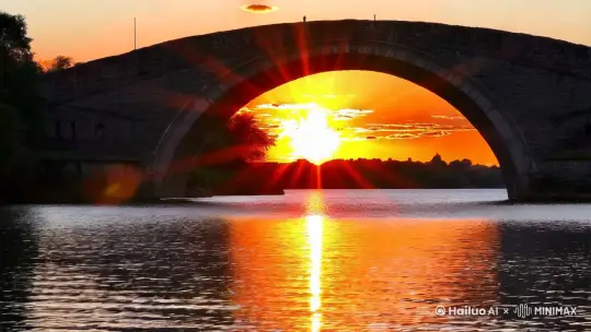 随着夕阳西下，天空被染上了一层柔和的橙红色调，云彩也披上了金色的外衣。在这座古老的石桥下，水面平静如镜，反射着天空的色彩，仿佛是另一个天空的倒影。桥洞的轮廓在水面上清晰可见，随着太阳的缓缓下沉，一束束阳光开始穿透桥洞，如同金色的箭矢，直指水面。阳光穿过桥洞的那一刻，时间仿佛凝固了。光线在桥洞的边缘变得柔和而温暖，它们缓缓地穿过，像是在诉说着古老的故事。每一束光线都带着太阳的余温，照亮了桥洞内部的每一个角落，也照亮了水面上的波纹，使得整个场景充满了神圣和宁静。随着太阳的继续下沉，光线的角度也在变化，桥洞中的金光开始逐渐拉长，它们在水面上投下长长的影子，如同时间的指针，记录着日落的进程。周围的空气似乎也被这些光线感染，变得温暖而透明，让人不禁屏息凝视，生怕打扰了这一刻的宁静。最终，当太阳完全落下，桥洞中的金光也渐渐消失，只留下水面上最后一抹余晖，和天空中渐渐暗淡的晚霞。这一刻的金光穿洞，如同一场短暂的梦境，让人在惊叹之余，也感受到了大自然的神奇和美丽。 by Hailuo AI Video Generator
