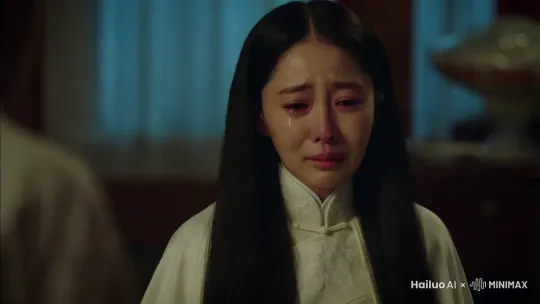 一个黑色长发30岁中国女子，穿着白色孝服，没有化妆，在房间里悲伤哭泣，光线昏暗，饱和度低，。，，写实风格 by Hailuo AI Video Generator
