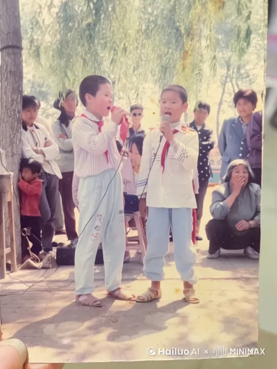 让里面的人都动起来，两个人继续说相声，最后手拉手鞠躬，然后走下台，台下人都鼓掌欢送 by Hailuo AI Video Generator