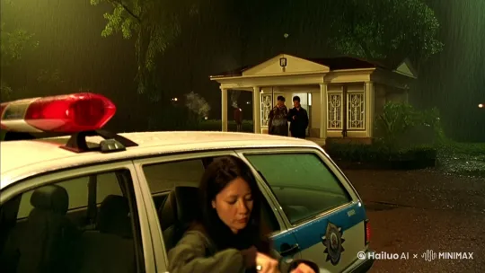 一场雨欲落又止，深夜空气里只有闷闷的热。
殡仪馆外停了一辆警车，大众帕萨特，左侧车尾刷着编号H3987，车窗开了一半。
外面一男一女挨着车窗抽烟，宗瑛坐在副驾上开一盒豆豉鲮鱼罐头，拉环断了，只能用刀。
刀尖稳力扎入，调整角度划绕半圈顺利启开，倒扣罐头，只滚下来一颗油腻的豆豉，孤零零地趴在凉掉的米饭上 by Hailuo AI Video Generator