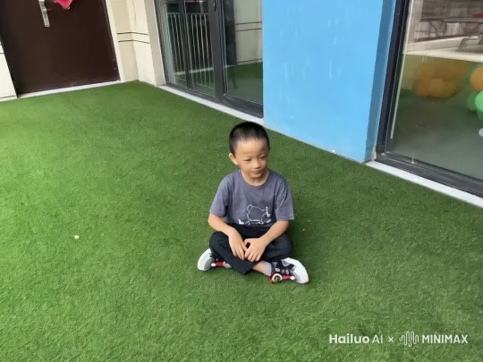 画面角落里走入一只矮矮胖胖的小黄人，它有着黄色的像胶囊形状的身体，戴着护目镜，穿着牛仔色的背带裤。它跑到画面的人物身边，然后从背后掏出一个黄澄澄的香蕉，期待地看着人物。 by Hailuo AI Video Generator