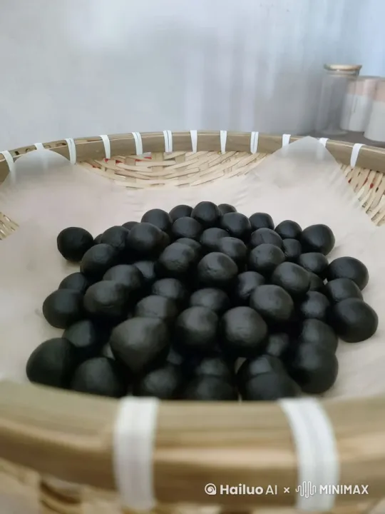 九蒸九晒芝麻丸，镜头360°宣传，绕着装芝麻丸的盘子转了一圈，[左移,右摇,跟随]，然后旁边有一个仙气飘飘的白衣道士过来，拿起一颗芝麻丸，很珍惜的看着 by Hailuo AI Video Generator