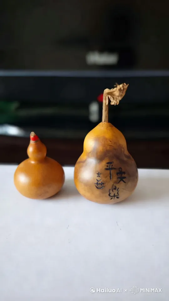 两个葫芦分别冒出一缕紫色烟雾,左边的葫芦顶端钻出一个小女孩,小女孩的形象就是动画片里的葫芦妹,她身穿红衣,耳朵上戴着两个小葫芦耳环。大葫芦顶端同时也冒出来一个葫芦男孩,也是葫芦娃中的形象,头顶小葫芦,腰间葫芦叶子,他们分别从葫芦顶端沿着葫芦壁滑下来到地面,抱起葫芦走到镜头前放下,放下时地面微微振动,葫芦妹和葫芦娃朝着镜头挥手,并且祝大家平安喜乐 by Hailuo AI Video Generator