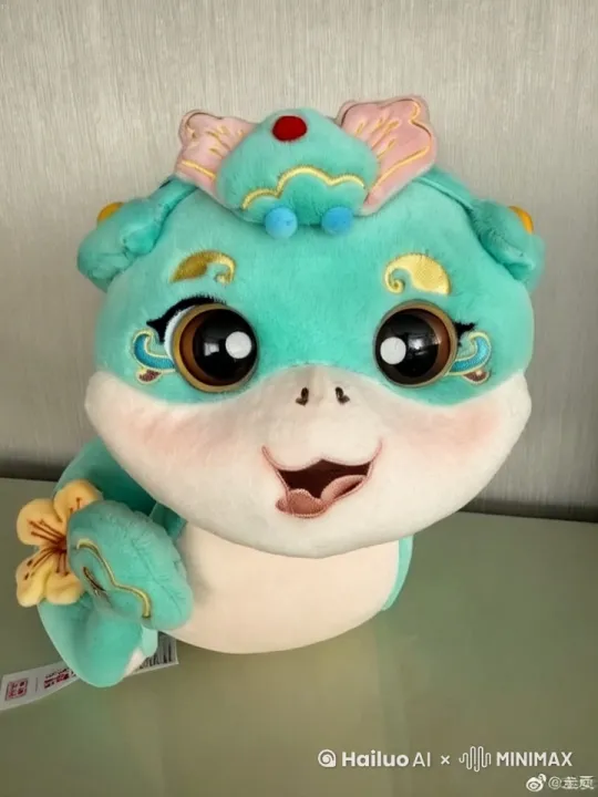 图中可爱的绒毛布偶蛇从嘴巴吐出一堆的红包，并说祝大家开工大吉！ by Hailuo AI Video Generator