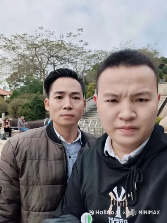 图片中的粮图片中的两人，进行比武，

两名格斗者以侧滑步迅速缩短间距，在距离三米处骤然加速对冲。左侧身形较矮者率先发动攻势，右腿呈45度角斜劈而下，胫骨破风之声清晰可闻，对手以左臂三角肌群硬抗的瞬间，右拳已如炮弹般直击肝区。受击者借势旋身卸力，后摆腿划出凌厉弧线直取太阳穴，却被精准截击——前臂与胫骨相撞发出闷响，双方同时后撤半步调整呼吸。

此刻攻防转换频率骤然提升，拳峰与胫骨的接触点迸发细密汗珠。高个武者突然变线，左刺拳虚晃后接俄罗斯勾踢，鞋跟距下颌仅差毫厘。矮个武者俯身闪过瞬间，双手撑地使出巴西战舞回旋踢，裤腿在空气中抽打出爆鸣。双方近身缠斗时，肘关节与膝关节形成精密力学对抗，地面细砂在鞋底摩擦下腾起微型尘暴。

节奏突变发生在第27秒，矮个武者假意后仰露出破绽，待对方重心前压刹那，突然施展泰式箍颈膝撞。七次连续膝击如液压机般冲击肋部，却在第八次被反制——对手突然沉腰发力，俄式过肩摔将攻势转化为抛物线运动。撞击地面的震颤尚未消散，胜者已用十字固锁死肘关节，败者手背青筋暴起，五指在沙地上犁出五道深痕。 by Hailuo AI Video Generator