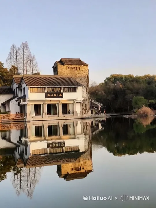 傍晚的古镇河边，夕阳西下，风吹柳叶，我静坐河边石凳上，手拿咖啡。 by Hailuo AI Video Generator