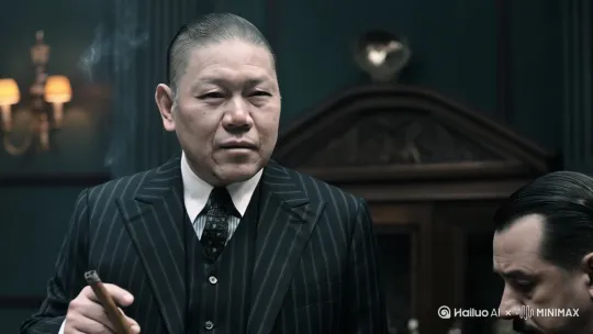 美国七八十年代的黑帮教父，年龄四十岁左右，眼神有威慑力，梳着油背头，手上掐着雪茄，嘴里在高谈阔论给他的手下，要符合电影教父的感觉，注意细节。 by Hailuo AI Video Generator