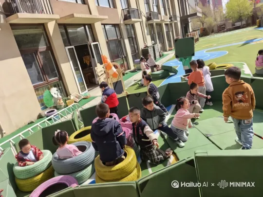 [固定镜头]在幼儿园操场上，孩子们在玩轮胎和海绵垫，突然天空中飘落很多糖果和继续，孩子在快乐的哄抢 by Hailuo AI Video Generator