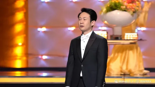 年轻的演员上台领奖，和美女主持人热情拥抱，向台下观众挥手致意 by Hailuo AI Video Generator