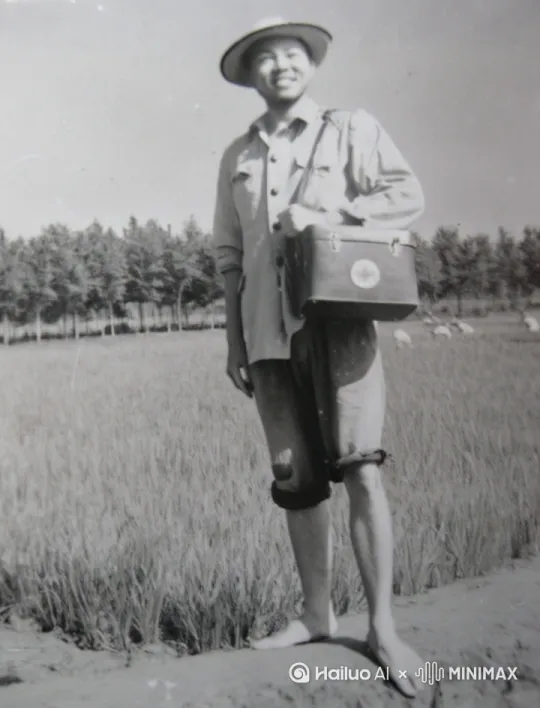 在1969年我曾在崇明岛新海农场当赤脚医生（应该算是中国第一代赤脚医生）留下这张照片，那天正好在巡视，为在稻田里的农友提供医疗服务，没有事的话也会下水稻里拨草…… by Hailuo AI Video Generator