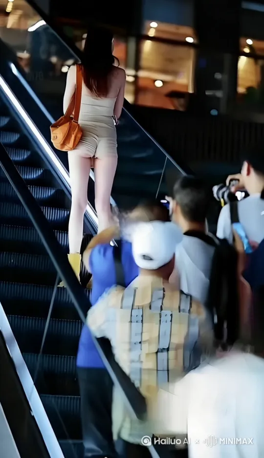 电梯上穿着热裤的美女，慢慢转身，妩媚一笑 by Hailuo AI Video Generator