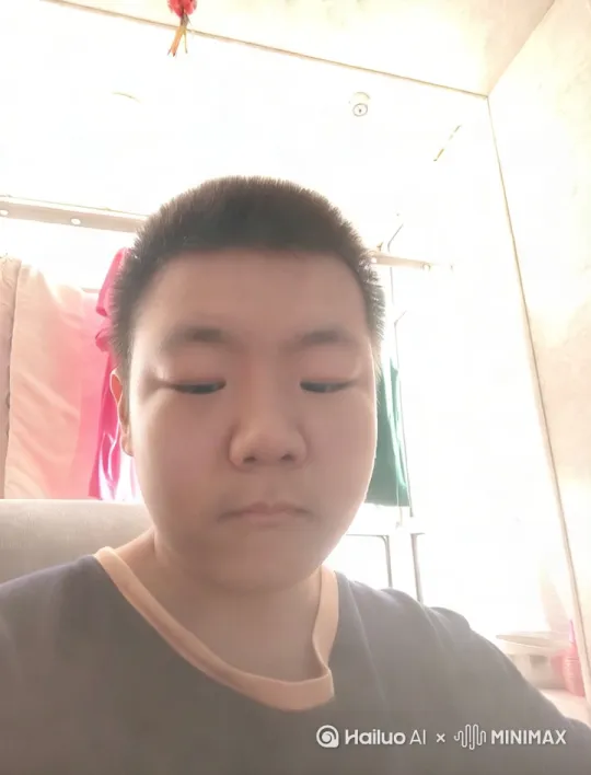 画面中的人带上了一副圆眼镜，眼睛变小了，【拉远】人的面前出现了一张桌子，他拿起桌上的笔，开始学习 by Hailuo AI Video Generator
