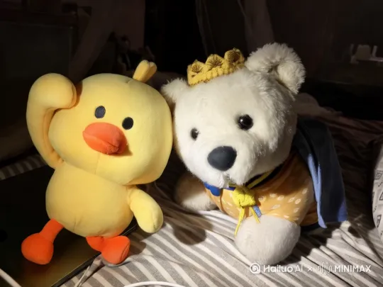白色的小熊突然活了过来，它的摇了几下，黄色的鸭子猝不及防的被它弄倒了；小熊动动耳朵，眨眨眼睛，动动鼻子，一副可爱的样子，然后打个哈气，以此同时，小鸭子仰面朝天哭了起来，小熊脑袋转呀转，脚跳呀跳，听到小鸭子哭声，转过头去，小鸭子坐了起来，小熊亲了它一下。 by Hailuo AI Video Generator
