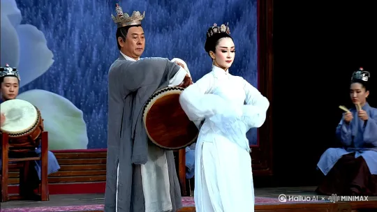 韩熙载褪去青灰外衣，头戴高冠，一身素白葛麻长衫，亲自击打羯鼓为舞娘伴奏！门生舒雅也敲起牙板附和着，主角王屋山正跳着唐代顶流“六爻舞”（也称“绿腰舞”）——长袖翻飞如云，踏足轻盈似雪，柔中带刚，仿佛下一秒就要“飞去逐惊鸿”
 绿腰舞是唐代贵族圈最火的女子独舞！节奏由缓到急，衣袖舒展如莲叶滚浪，身姿摇曳似乱雪萦风。 by Hailuo AI Video Generator