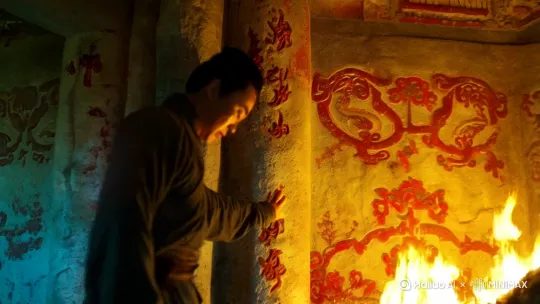 墙壁上斑驳的壁画,那些朱砂绘就的图案在跳动的火光中仿佛活了过来。
"这墓室构造,倒是前所未见。"李墨喃喃自语,手指轻轻抚过墙壁上凹凸不平的纹路。作为一名经验丰富的盗墓贼,他见过太多古墓,但眼前这座却让他感到莫名的不安。
墓道尽头是一扇青铜门,门上雕刻着繁复的云纹,正中镶嵌着一块巴掌大的玉璧。李墨凑近细看,玉璧上隐约可见细密的纹路,在火光下泛着幽幽的青光。
"好东西。"他舔了舔干燥的嘴唇,从腰间取出特制的工具。然而就在他的手指即将触碰到玉璧的瞬间,一阵刺骨的寒意突然从脚底窜上来。
李墨猛地后退一步,火折子差点脱手。他感觉自己的心跳突然加快,耳边响起细微的嗡鸣声,那声音越来越响,最后变成了一种诡异的吟唱,仿佛有无数人在他耳边低语。
青铜门无声无息地打开了。
门后的景象让李墨倒吸一口冷气——这是一间圆形的墓室,穹顶上镶嵌着无数夜明珠,宛如星空。正中央是一座白玉祭坛,祭坛上悬浮着一盏青铜古灯,灯芯处跳动着幽蓝色的火焰。
李墨的视线被那盏古灯牢牢吸引,他不由自主地向前走去。随着他的靠近,古灯的火焰突然剧烈跳动起来,蓝色的火苗窜起三尺高。
"擅闯者,当受永世之罚。"
一个沙哑的声音在墓室中回荡,李墨还未来得及反应,那团蓝色火焰就化作一道流光,直接没入了他的胸口。剧烈的疼痛让他跪倒在地,他感觉有什么东西在自己的血液中流淌,所过之处如同被烈火灼烧。
不知过了多久,疼痛渐渐消退。李墨颤抖着站起来,发现自己全身都被冷汗浸透。他摸了摸胸口,那里没有任何伤痕,但皮肤下似乎有什么东西在隐隐跳动。
回到地面后,李墨很快就发现了自己的异常。一次意外中,他的手臂被利刃划伤,伤口却在眨眼间愈合如初。起初他以为是错觉,直到有一次,他亲眼看着自己折断的手指在几个呼吸间恢复原状。
这种能力让他既兴奋又恐惧。他开始频繁地做同一个梦,梦中总有一个身穿龙袍的身影站在祭坛前,手中捧着一盏青铜古灯。每次醒来,他都能感觉到胸口那团火焰在跳动,仿佛在指引着他什么。
三个月后,李墨决定重返那座古墓。这一次,他做了充分的准备,不仅带上了各种工具,还特意查阅了大量古籍。然而当他找到当初的入口时,却发现那里已经变成了一片废墟,仿佛从未有过什么古墓。
站在废墟前,李墨摸着胸口的印记,他知道,自己必须找到答案。这不仅关乎他的性命,更关乎一个埋藏千年的秘密。 by Hailuo AI Video Generator