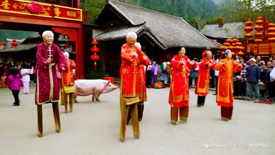在中国农村的正月里，一群有男有女的老年人正在村口的广场上踩着高跷在表演，其中有一头大肥猪也在队伍中一起演出。 by Hailuo AI Video Generator