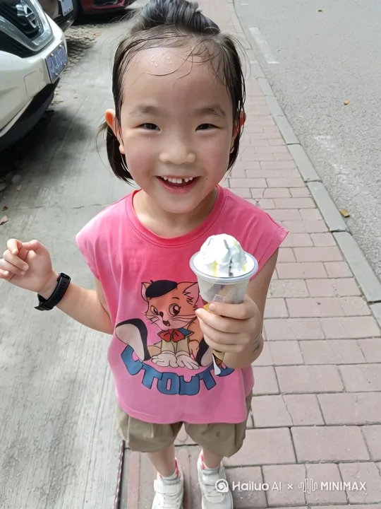 小女孩冰淇淋里钻出一个冰淇淋小人，向小女孩打招呼，小女孩惊讶地看着它。冰淇淋小人慢慢长大，跳下来，身体变成水晶般晶莹剔透，最后变成像小女孩一模一样。[左移,上升] by Hailuo AI Video Generator